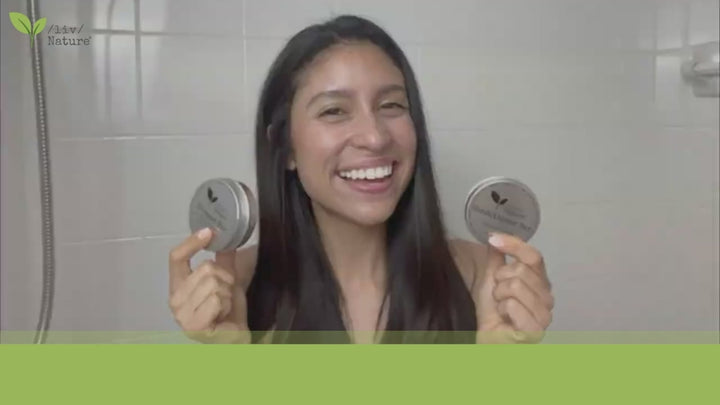 A woman inside the bathroom showing how to use the liv nature shampoo and conditioner combo set. 